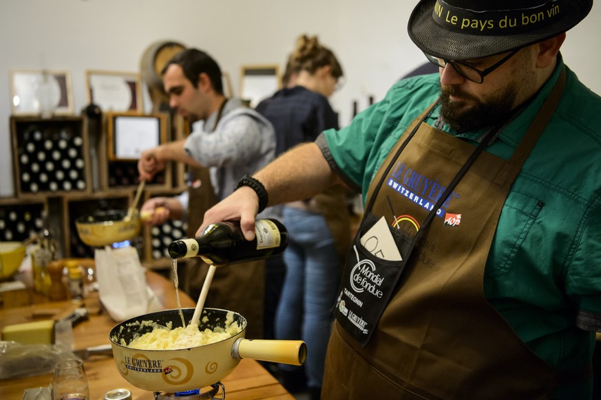 Des participants preparent une fondue pendant la phase qualificative lors du 1er Mondial de fondue, le premier concours au monde de preparation de fondue ce samedi 21 novembre 2015 a Tartegnin dans le ...