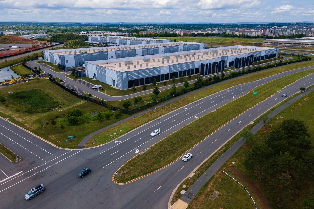 FILE - Cars drive past data centers that house computer servers and hardware required to support modern internet use, such as artificial intelligence, in Ashburn, Virginia, July 16, 2023. (AP Photo/Te ...
