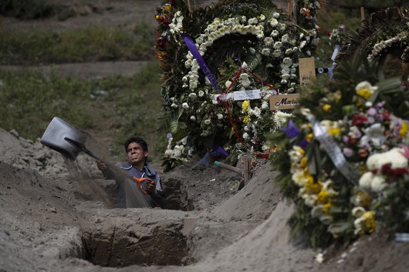 A cemetery worker digs a grave in a section of the Valle de Chalco Municipal Cemetery which opened early in the coronavirus pandemic to accommodate the surge in deaths, on the outskirts of Mexico City, Thursday, Sept. 24, 2020.(AP Photo/Rebecca Blackwell)