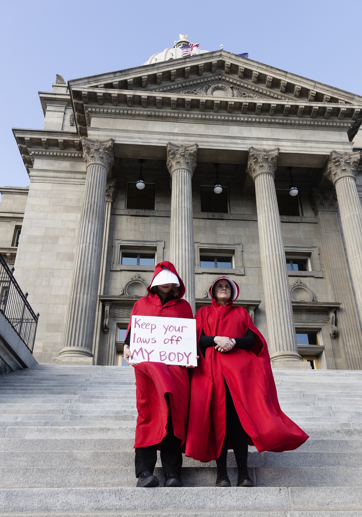 FILE - Two people stand on the steps of the Idaho State Capitol Building, during a protest, in downtown Boise, Idaho on May 3, 2022. The U.S. Supreme Court ruling overturning Roe v. Wade has legal adv ...