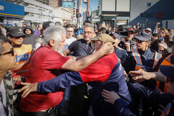 epa12328038 People clash during an election campaign event for Argentine President Milei in Lomas de Zamora, Argentina, 27 August 2025. Milei was evacuated during the event in Buenos Aires province af ...