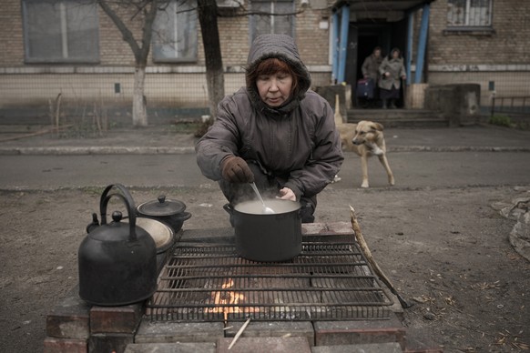Eine Frau bereitet ihre Mahlzeit auf der Strasse vor.