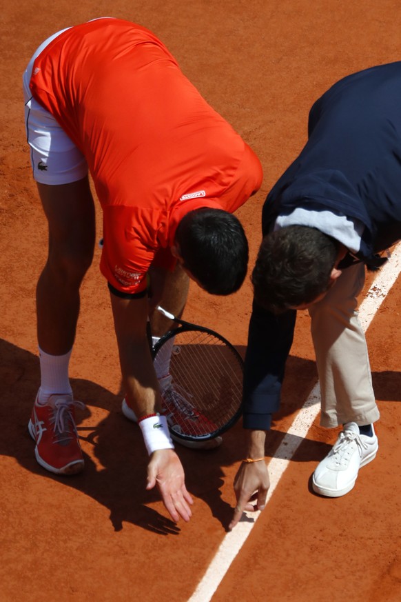 Serbia&#039;s Novak Djokovic, left, discusses a ball mark with the referee as he plays against Austria&#039;s Dominic Thiem during the men&#039;s semifinal match of the French Open tennis tournament a ...