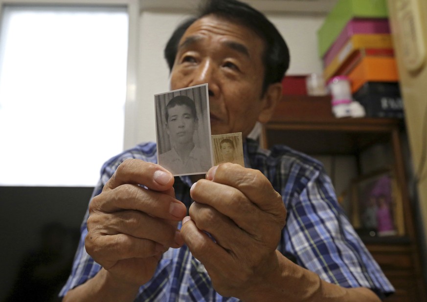 In this Aug. 17, 2018, photo, Lee Soo-nam, 76, shows photos of his brother Ri Jong Song in North Korea during an interview at his home in Seoul, South Korea. Lee is among about 200 war-separated South ...