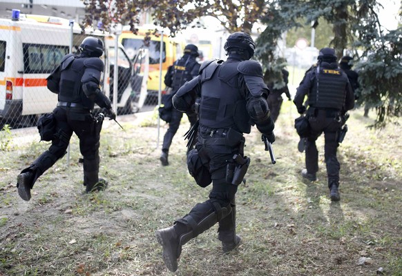 Hungarian riot policemen run as they are deployed at the border crossing with Serbia in Roszke, Hungary September 16, 2015. Hungarian riot police, backed by water cannon and armoured vehicles, moved i ...