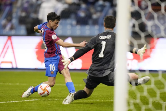 Barcelona&#039;s Pedri passes the ball in front of Real Madrid&#039;s goalkeeper Thibaut Courtois during the Spanish Super Cup semi final soccer match between Barcelona and Real Madrid at King Fahd st ...