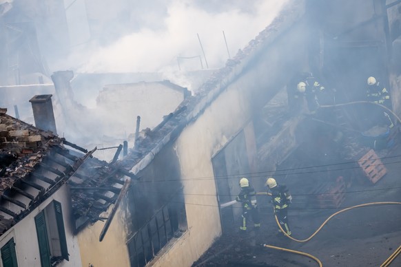 Un pompier tente de maitriser les flammes lors d'un incendie ce lundi 20 avril 2026, a Saxon, Suisse. Un important incendie avec un fort degagement de fumee s'est declare lundi apres-midi da ...