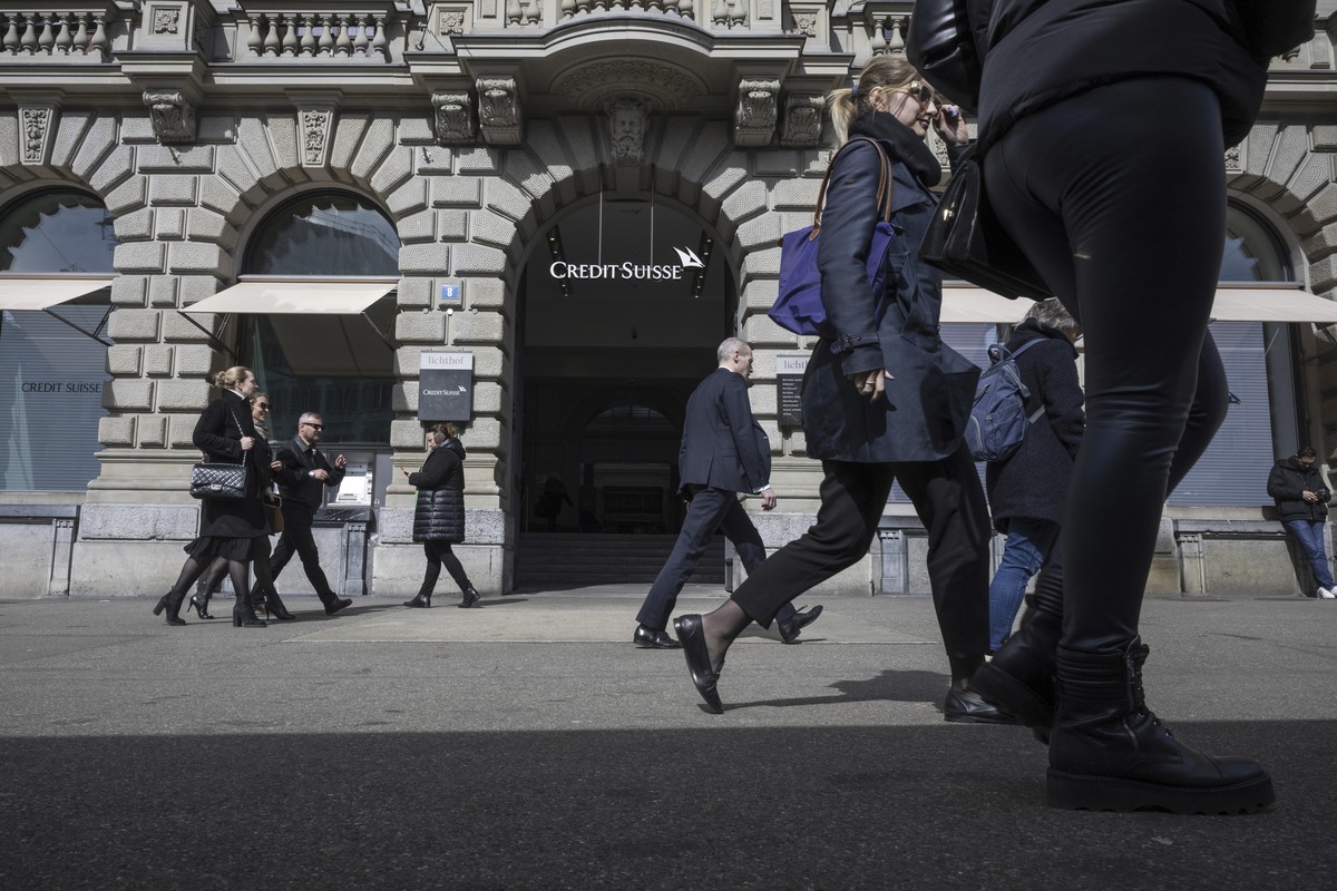 People walk past the entrance of Swiss bank Credit Suisse at their headquarters in Zurich, Switzerland, Thursday March 16, 2023. Credit Suisse's shares soared 30% on Thursday after it announced i ...