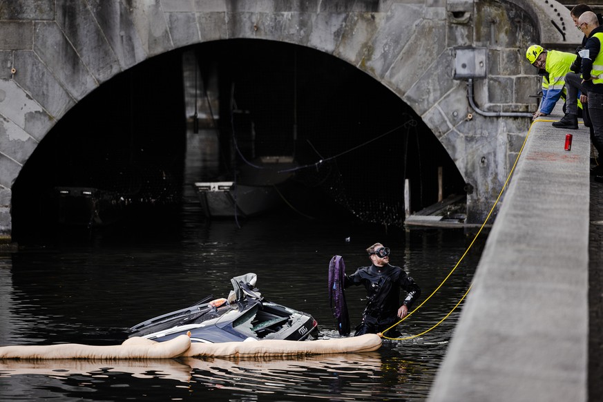 Rettungskraefte bergen einen Personenwagen neben der Muensterbruecke aus der Limmat, am Freitag, 5. November 2021 in Zuerich. (KEYSTONE/Michael Buholzer)..