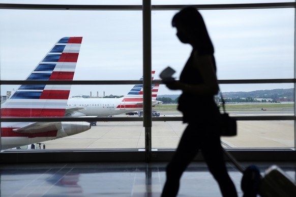 epa09233964 Travellers walk through a terminal at Ronald Reagan Washington National Airport in Arlington, Virginia, USA, 28 May 2021. Air travel is expected to increase over the Memorial Day weekend,  ...