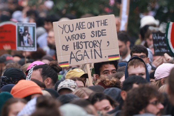 epa11645716 A protester walks with a placard that reads ?You are on the wrong side of history again? during a pro-palestinian rally in Berlin, Germany, 06 October 2024. Upcoming 07 October 2024 marks  ...