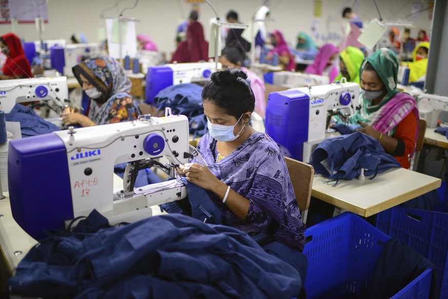 FILE - Garment employees work at Arrival Fashion Limited in Gazipur, Bangladesh, Saturday, March 13, 2021. The European Union warned consumers to stop using their clothes like throwaway items and said ...