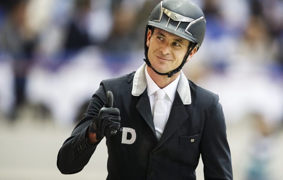 epa05067903 Steve Guerdat from Switzerland acknowledges the crowd as his horse Nino des Buissonnets sticks its tongue out, after winning the first place of the Rolex Grand Prix of show jumping at the  ...