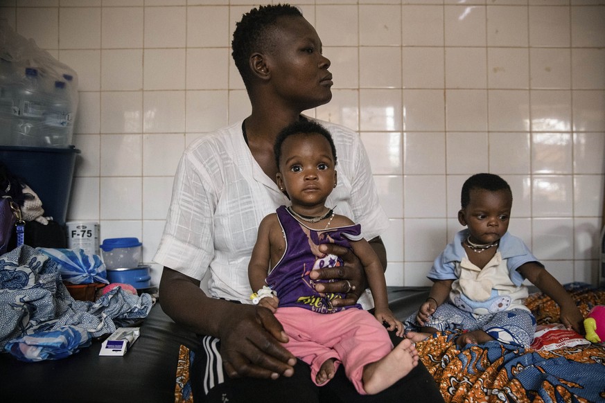 FILE- Malnourished children wait for treatment in the pediatrics department of Boulmiougou hospital in Ouagadougou, Burkina Faso, on April 15, 2022. The United Nations food agency says millions of hun ...