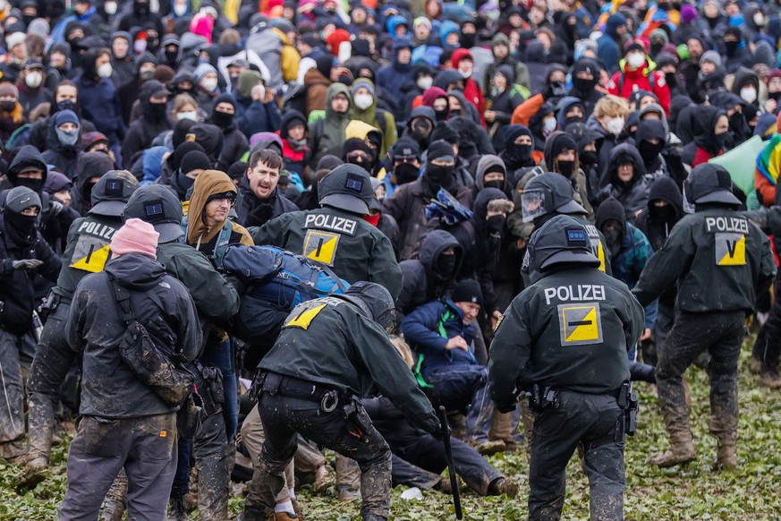 epa10405067 Police officers (front) clash with protesters during a rally of climate protection activists near the village of Luetzerath, Germany, 14 January 2023. Luetzerath in North Rhine-Westphalia  ...