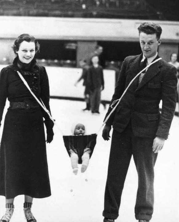 Parents taking their baby ice skating, 1930s.