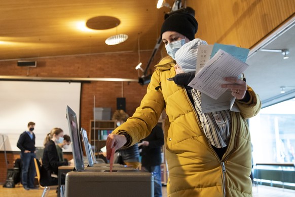 Eine Waehlerin wirft ihre Wahlzettel und Abstimmungszettel fuer die Berner Gemeinderats- und Stadtratswahlen, sowie die eidgenoessischen Abstimmungen in die Urnen, am Sonntag, 29. November 2020, in Be ...