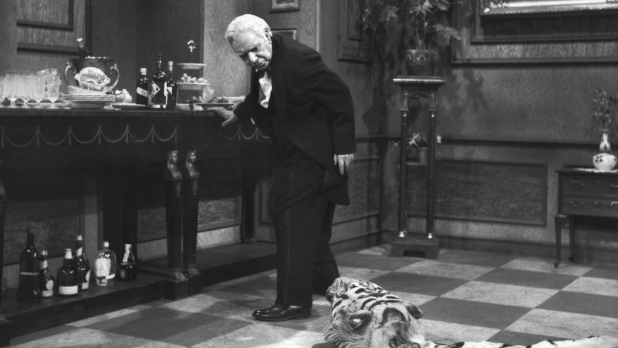 Butler James, gespielt von Freddie Frinton, schaut missbilligend zu dem auf dem Boden liegenden Tigerfell, das eine staendige Stolperfalle auf dem Weg von und zur Anrichte ist. (KEYSTONE/epa/DPA/NDR/S ...