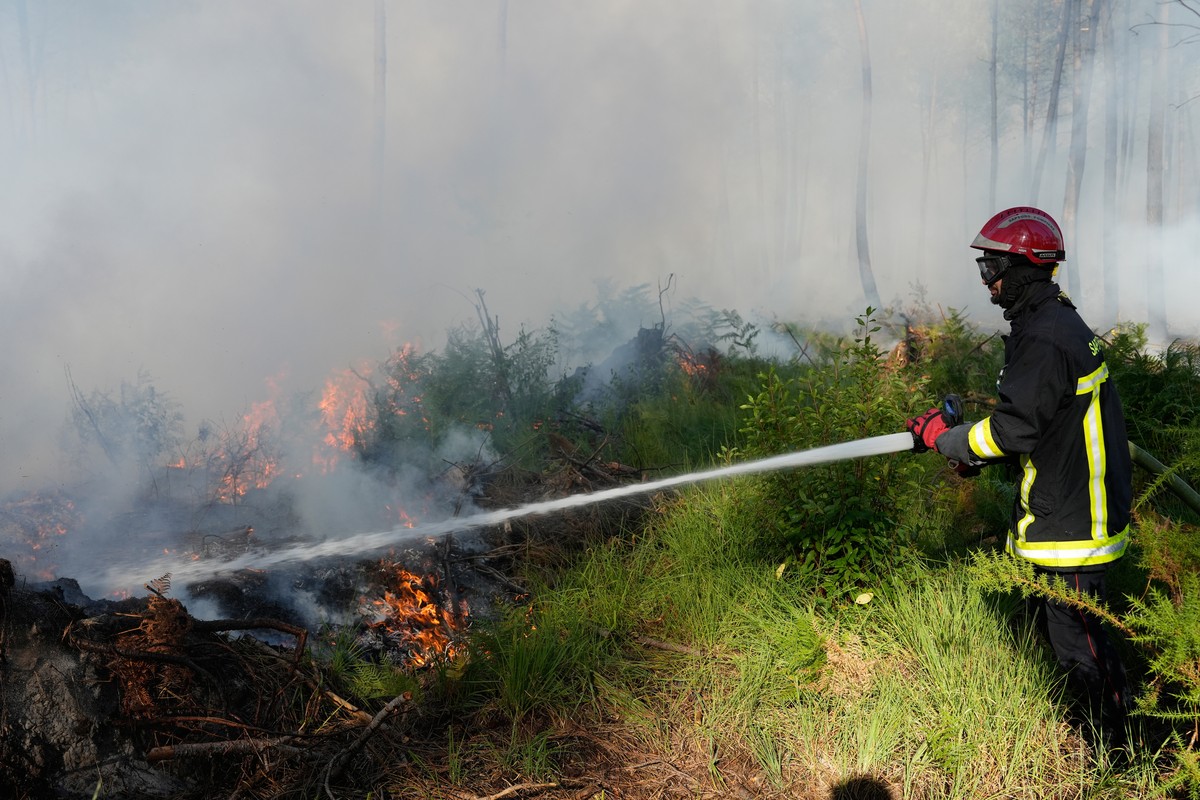 A firefighter works to suppress flames near Lacanau, as wildfires rage outside Bordeaux, France, Monday, July 27, 2026. (AP Photo/Baz Ratner)
France Wildfires