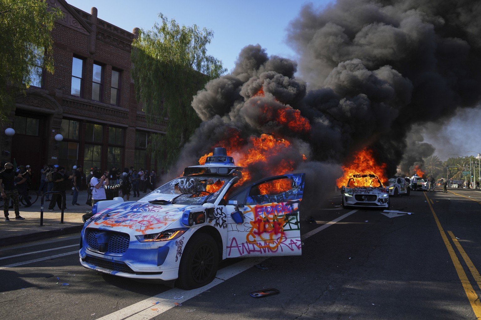 FILE - Multiple Waymo taxis burn near the Metropolitan Detention Center of downtown Los Angeles, Sunday, June 8, 2025, following last night&#039;s immigration raid protest. (AP Photo/Eric Thayer, File ...