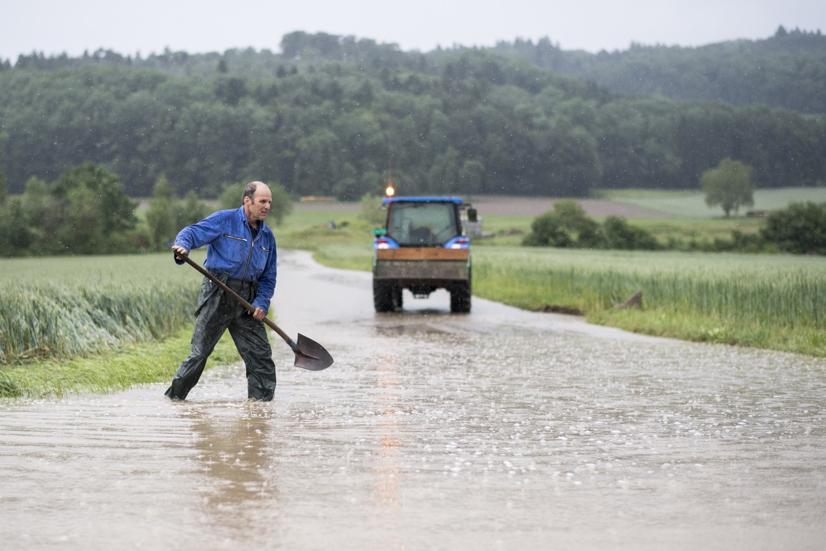 CAPTION CORRECTION - Ein Mann laeuft mit einer Schaufel auf einer ueberfluteten Strasse, aufgenommen am Mittwoch, 8. Juni 2016, in Dottikon. Durch den starken Regen und Unwetter kam es zu Ueberschwemm ...