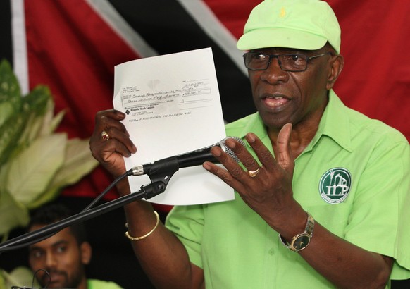 Former FIFA vice president Jack Warner hold a copy of a check while he speaks at a political rally in Marabella, Trinidad and Tobago, Wednesday, June 3, 2015. Warner made a televised address Wednesday ...