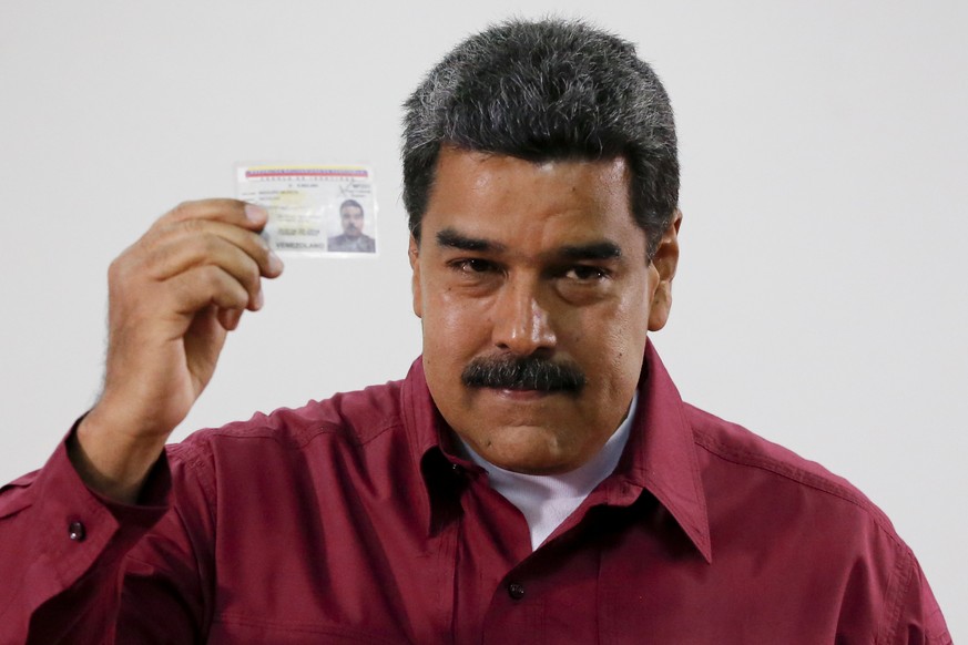 Venezuela&#039;s President Nicolas Maduro showed his ID after voting during presidential elections in Caracas, Venezuela, Sunday, May 20, 2018. Amidst hyperinflation and shortages of food and medicine ...