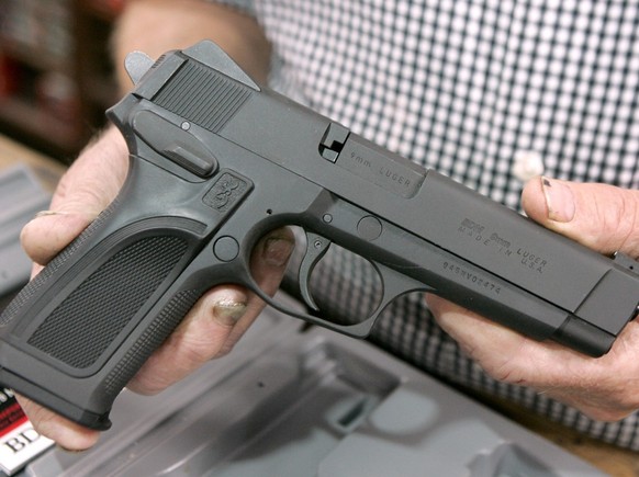 Chris Fulster, of Broadway Bait Rod and Gun, displays a 9mm semi-automatic pistol at his shop in Sacramento, Calif., Thursday, June 26, 2008. The Supreme Court ruled 5-4 to strike down the District of ...