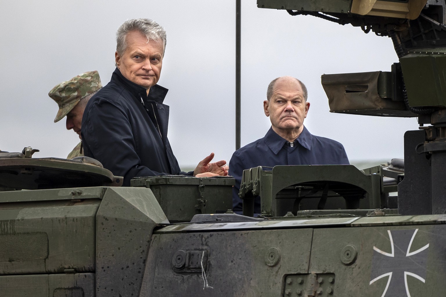 German Chancellor Olaf Scholz, right, and Lithuania&#039;s President GitanasNauseda ride on an armored military vehicle during the Lithuanian-German military exercise &#039;Grand Quadriga&#039; at a t ...