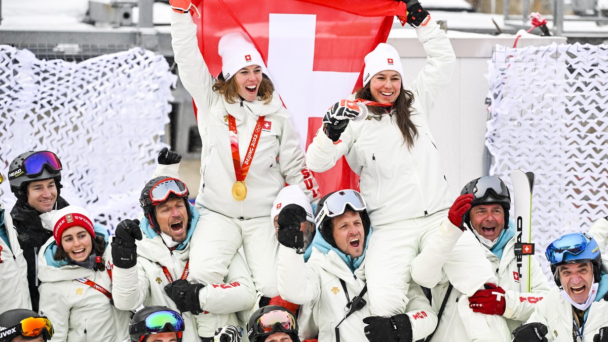 epa09765005 Gold medalist Michelle Gisin (up L) of Switzerland and silver medalist Wendy Holdener of Switzerland celebrate with their team after the victory ceremony of the Women's Alpine Skiing  ...