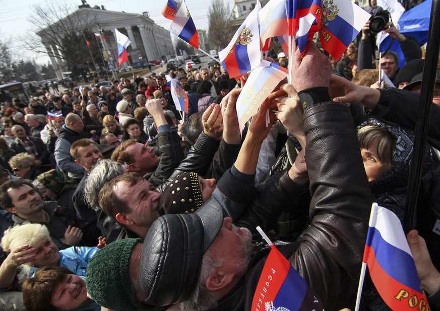 Russische Flaggen werden unter den Demonstranten verteilt.