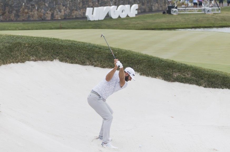 epa10097870 Golfer Dustin Johnson of the United States in the sand on the 18th hole during the first round of the LIV Golf Bedminster invitational, part of the new LIV Golf Invitational Series, at the ...