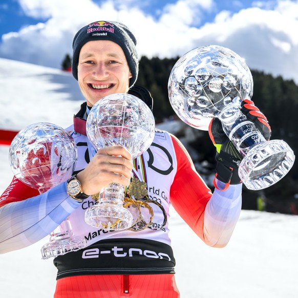 epa10532307 Marco Odermatt of Switzerland poses with the men&#039;s overall crystal globe trophy and the men&#039;s giant slalom crystal globe trophy and the men&#039;s super-g crystal globe trophy af ...