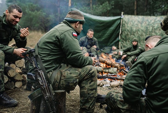 epa09578278 A handout photo made available by Polish Territorial Defence Force shows Polish soldiers rest during &#039;Operation Strong Support&#039; near the Polish-Belarusian border crossing in Kuzn ...