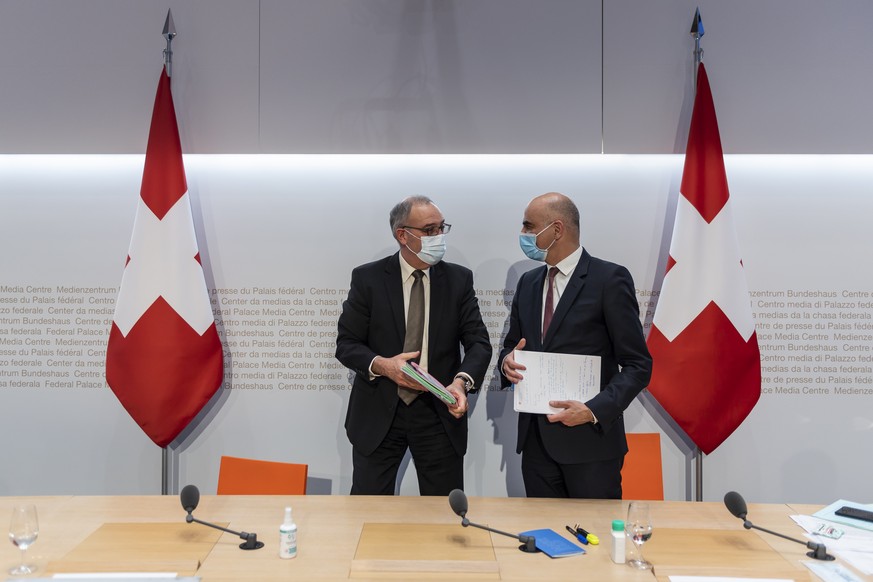 Bundesratspraesident Guy Parmelin, links, diskutiert mit Bundesrat Alain Berset nach der Medienkonferenz ueber die neusten Massnahmen zur Bewaeltigung der Krise um die Pandemie des Coronavirus COVID-1 ...