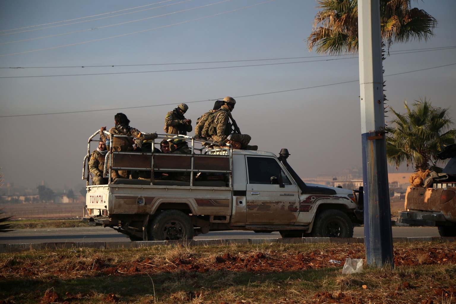 epa11752873 Armed men sit in the back of a truck driving in Aleppo after rebel forces took control of the city, in Aleppo, Syria, 02 December 2024. According to the Syrian Observatory for Human Rights ...