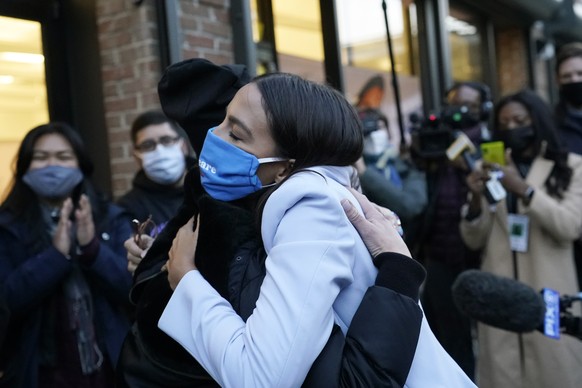 U.S. Rep. Alexandria Ocasio-Cortez, D-N.Y., right, embraces New York State Senator Alessandra Biaggi, a Democrat who represents the Working Families Party, while speaking to members of her staff and v ...