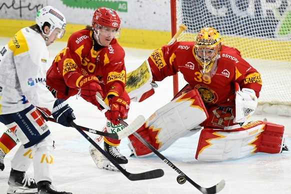 Tigers Juuso Riikola, Mitte und Goalie Luca Boltshauser, im Kampf um den Puck gegen Ambris William Hedlund, links, beim Eishockey-Qualifikationsspiel der National League, zwischen den SCL Tigers und d ...