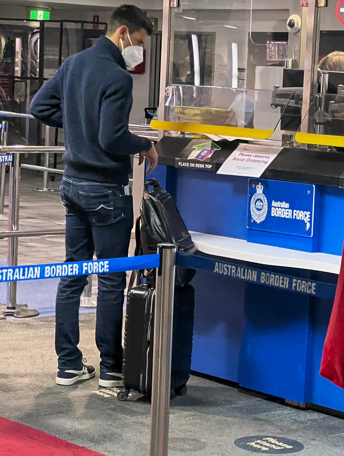 Serbia's Novak Djokovic, the Australian Open defending champion, waits at an Australian Border Force desk on his arrival at Melbourne Airport, Wednesday, Jan. 5, 2022. Locked in a dispute over hi ...