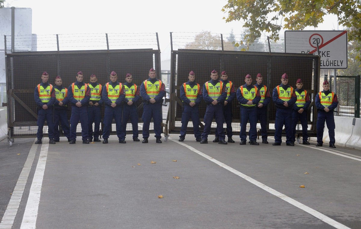 epa04988827 Hungarian police officers stand guard in front of the iron gate between Hungary and Serbia during the official reopening of the Roszke-Horgos border crossing in Roszke, 180 kilometers sout ...