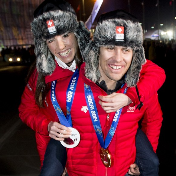Men's super-combined gold medalist Sandro Viletta of Switzerland, front, and Women's biathlon 15K individual silver medalist Selina Gasparin of Switzerland, back, arrive at the House of Swit ...