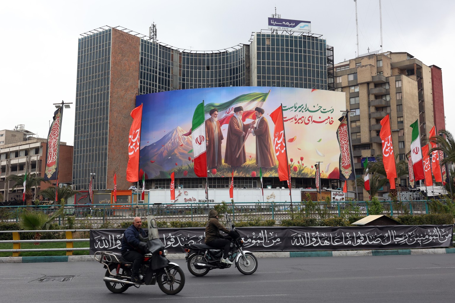 epa12808833 People drive past a huge billboard showing the late Iranian supreme leaders Ayatollah?Ruhollah Khomeini?(L), Ayatollah?Ali?Khamenei?(C), and the new Iranian supreme leader Ayatollah?Mojtab ...