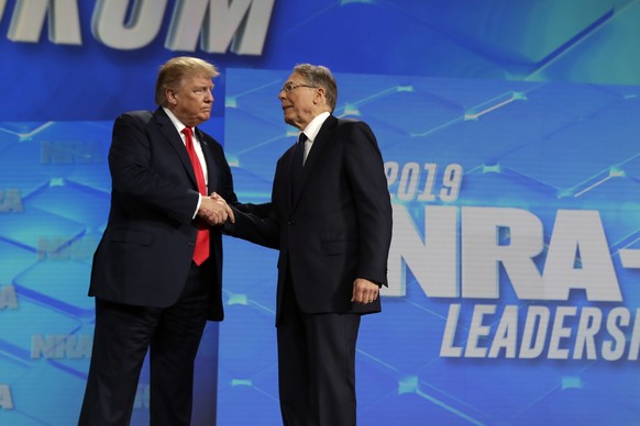 FILE - President Donald Trump shakes hands with NRA executive vice president and CEO Wayne LaPierre, has he arrives to speak to the annual meeting of the National Rifle Association, Friday, April 26,  ...