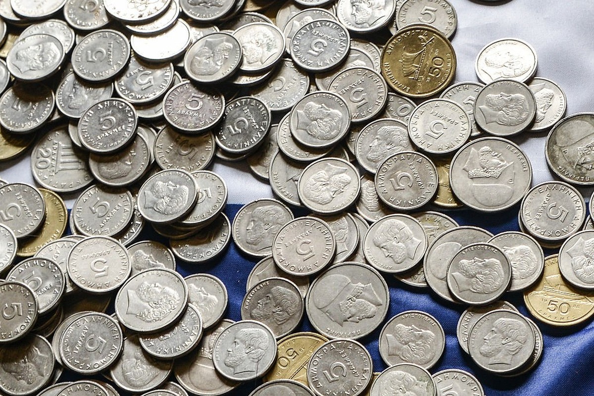 Several coins of old Drachmas on a Greek national flag. (Photo by Wassilios Aswestopoulos/NurPhoto) (Photo by NurPhoto/NurPhoto via Getty Images)
