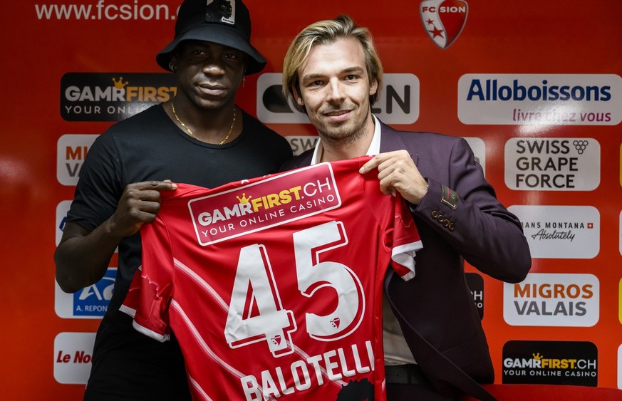 Mario Balotelli of Italy and new FC Sion soccer player, left, poses with Barthelemy Constantin, right, sport director of FC Sion, during a press conference at the Stade de Tourbillon stadium, in Sion, ...