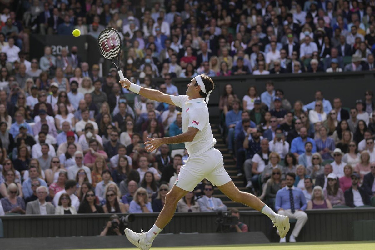 Switzerland's Roger Federer plays a return to Poland's Hubert Hurkacz during the men's singles quarterfinals match on day nine of the Wimbledon Tennis Championships in London, Wednesday ...