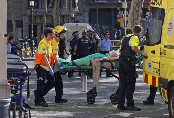 epa06148678 Mossos d&#039;Esquadra Police officers and emergency service workers move an injured after a van crashes into pedestrians in Las Ramblas, downtown Barcelona, Spain, 17 August 2017. Accordi ...