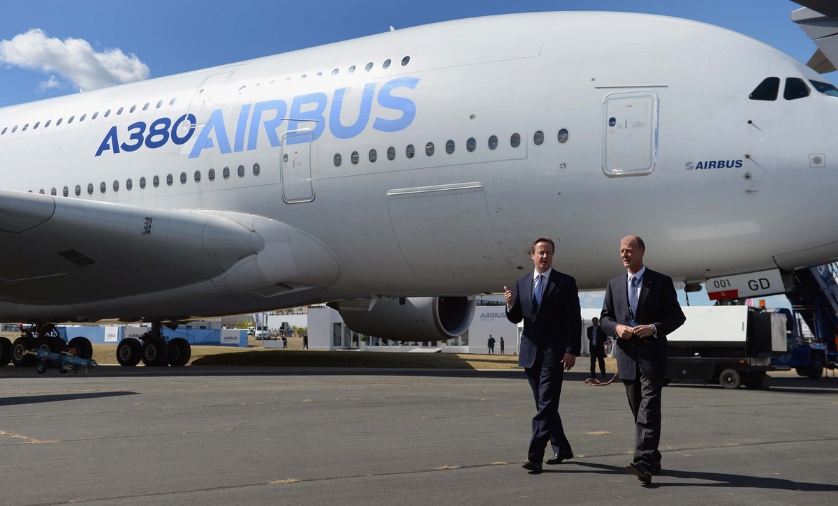 Britain's Prime Minister David Cameron second right, and Tom Enders, the chief executive of Airbus Group, walk by an Airbus A380, during a visit to the 2014 Farnborough Airshow in Hampshire, Engl ...