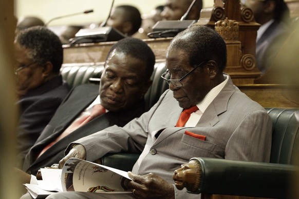 epa06311949 (FILE) - Zimbabwean President Robert Mugabe (R) is flanked by his deputy Vice President Emmerson Mnangagwa (L) as he reads a copy of the country&#039;s 2017 National Budget in the house of ...