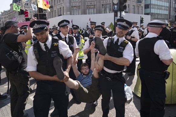epa07515958 An Extinction Rebellion climate change protestor is detained by police during a demonstration at Oxford Circus in London, Britain, 19 April 2019. Extinction Rebellion climate change protes ...